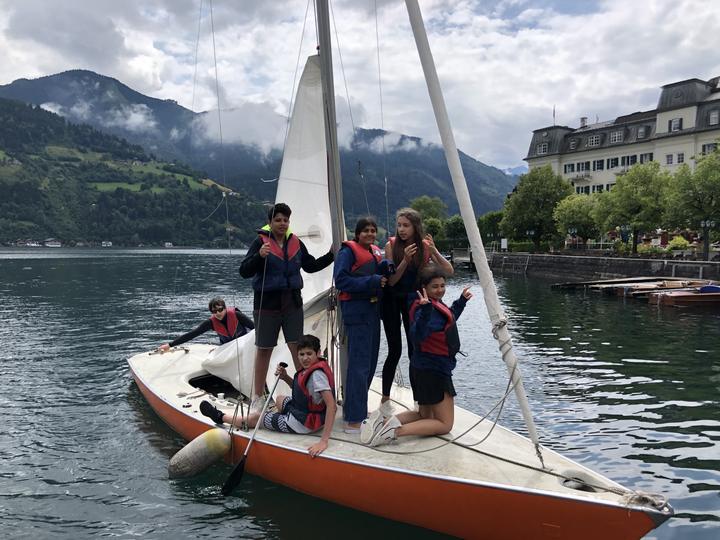 Campers in life jackets on a sailing boat on Lake Zell