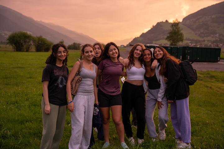Group of teenage campers smiling together at dusk