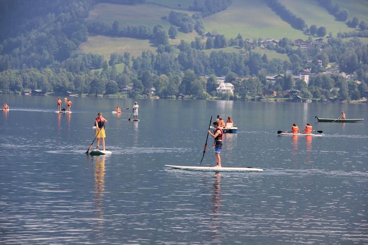 Campers stand-up paddleboarding on the lake