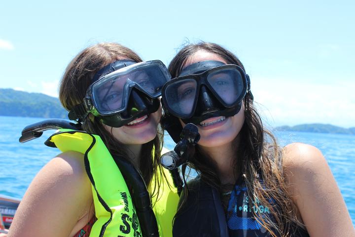 Two girls in snorkel masks on a boat