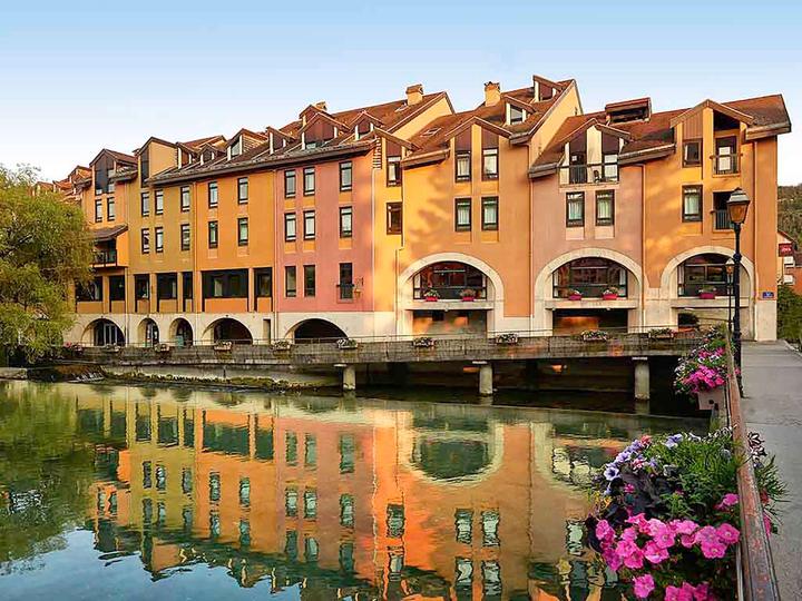 Hotel building reflected in a canal in Annecy