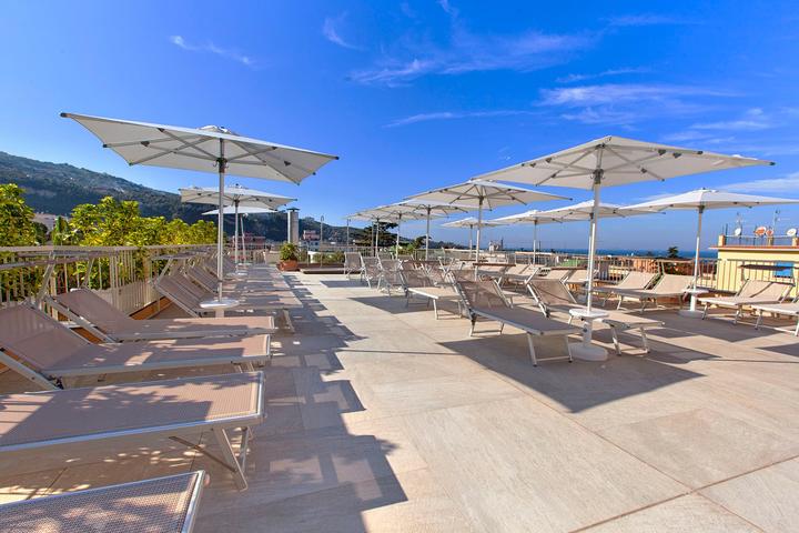 Rooftop sun terrace with loungers and parasols at a hotel in Sorrento