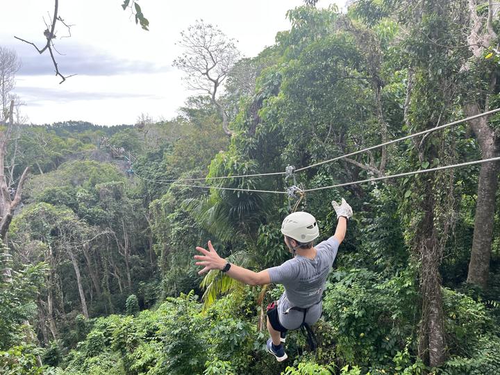 A teen on a zipline over the rainforest