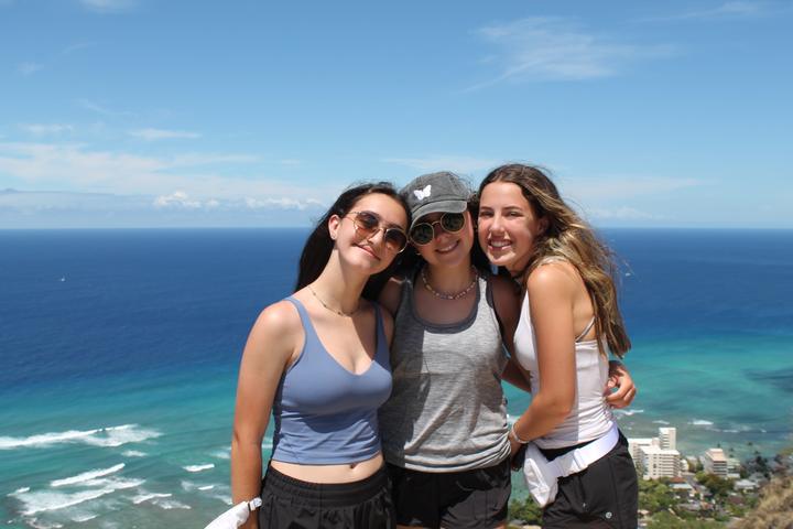 Three girls at a lookout above the ocean in Hawaii