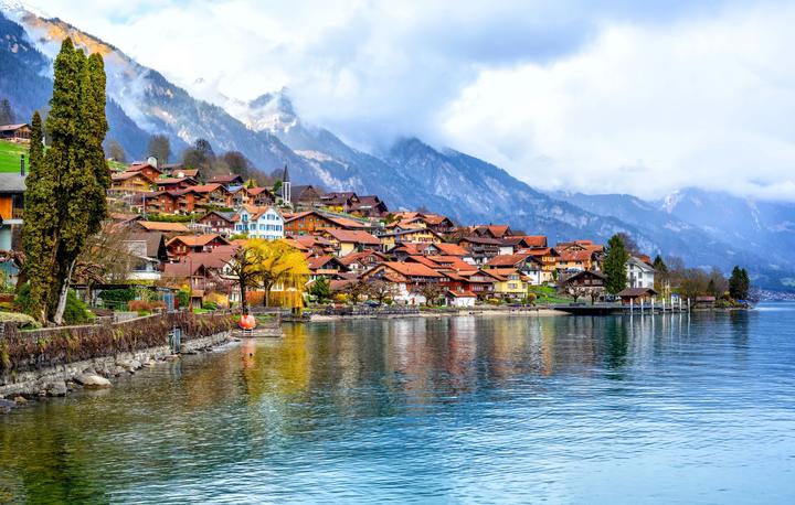 A lakeside village of chalets beneath snowy peaks in the Swiss Alps