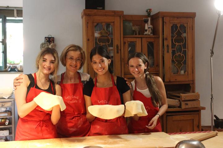 Girls holding up their dough at a cooking class in Perugia