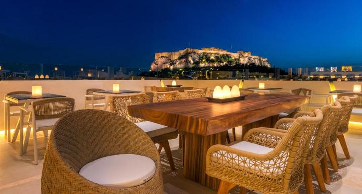 Hotel rooftop terrace in Athens looking up at the floodlit Acropolis