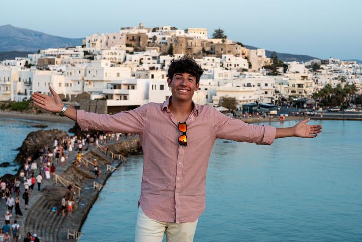 A boy with his arms out above Naxos town