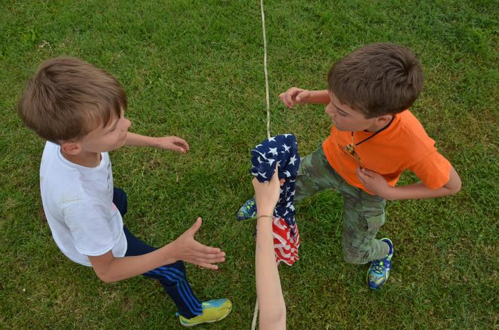 Two boys playing Steal the Flag on the grass