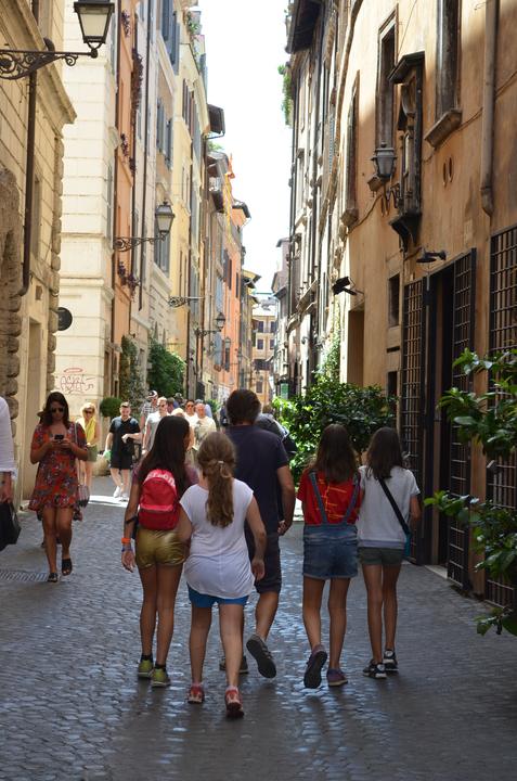 Campers walking down a narrow street in Rome's historic centre