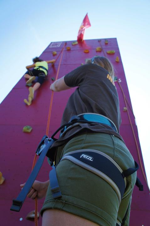 An instructor belaying a camper on the climbing wall