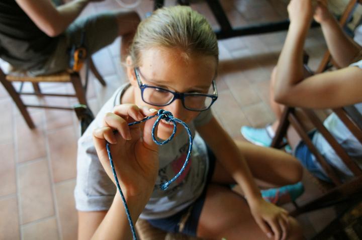 A camper practising a knot during a skills session