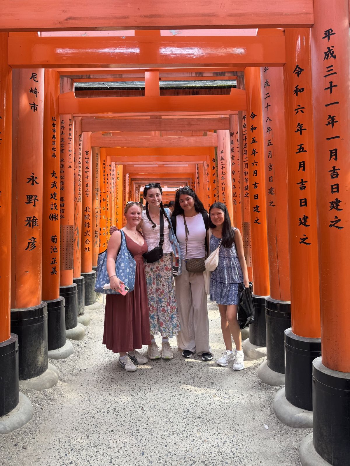Girls among the red torii gates of Fushimi Inari in Kyoto