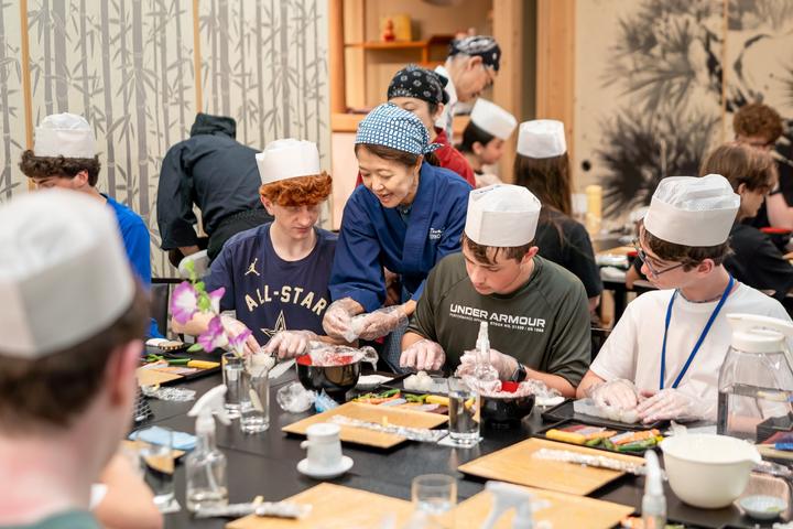 Teens making sushi with a chef
