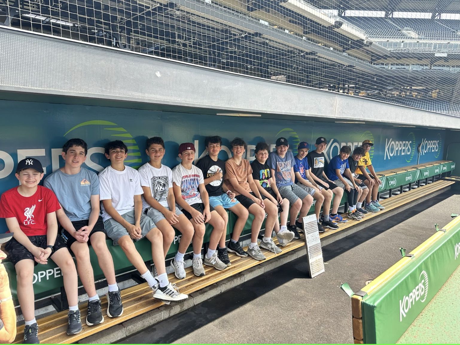 Boys sitting in a ballpark dugout