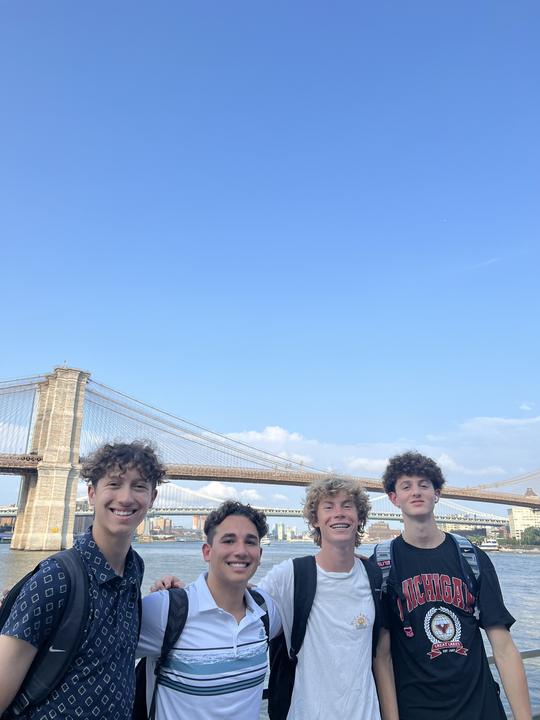 Four boys with the Brooklyn Bridge behind them