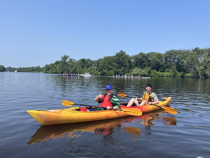 Two teens kayaking on a river in Boston