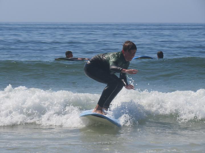 Camper surfing a small wave in a wetsuit