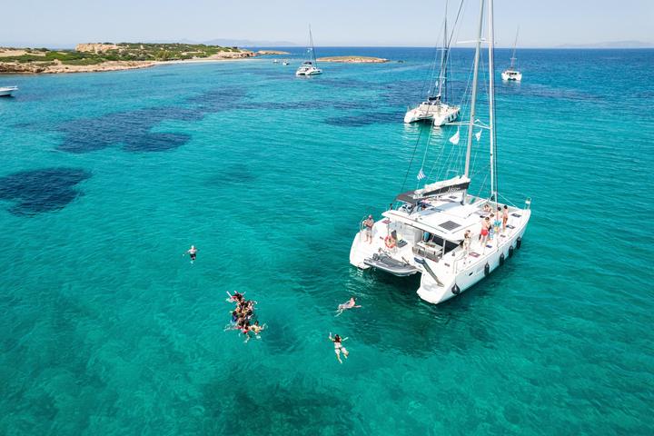 Swimmers off a catamaran in a turquoise bay