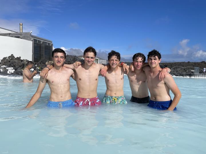 Boys in the milky-blue water of an Icelandic geothermal lagoon