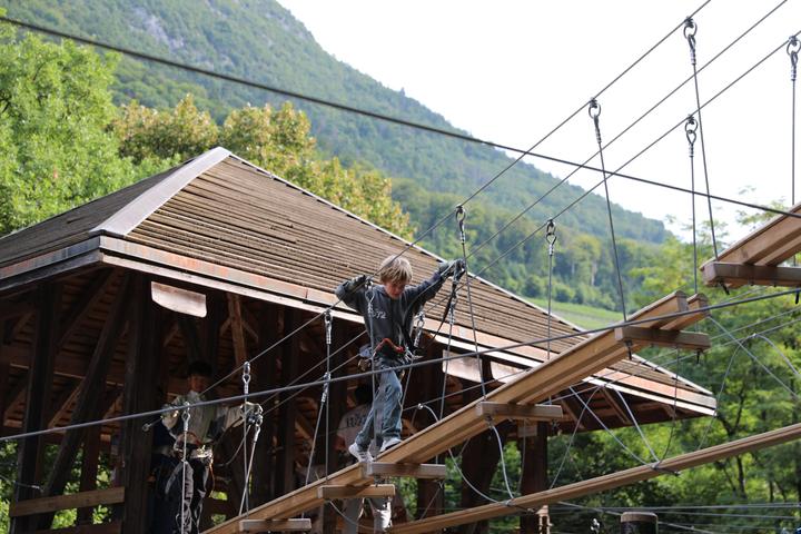 Camper crossing the high-ropes course in the forest