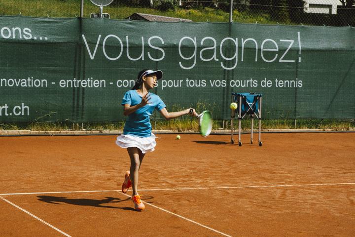 Player reaching for a ball on the clay courts