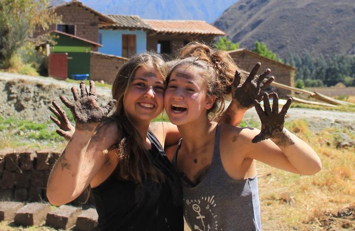 Two girls with muddy hands on a service project