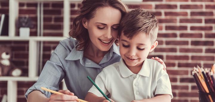 A mother and her young son drawing together