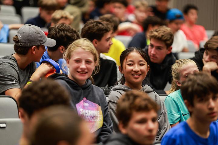 Campers from different countries smiling together at a camp meeting