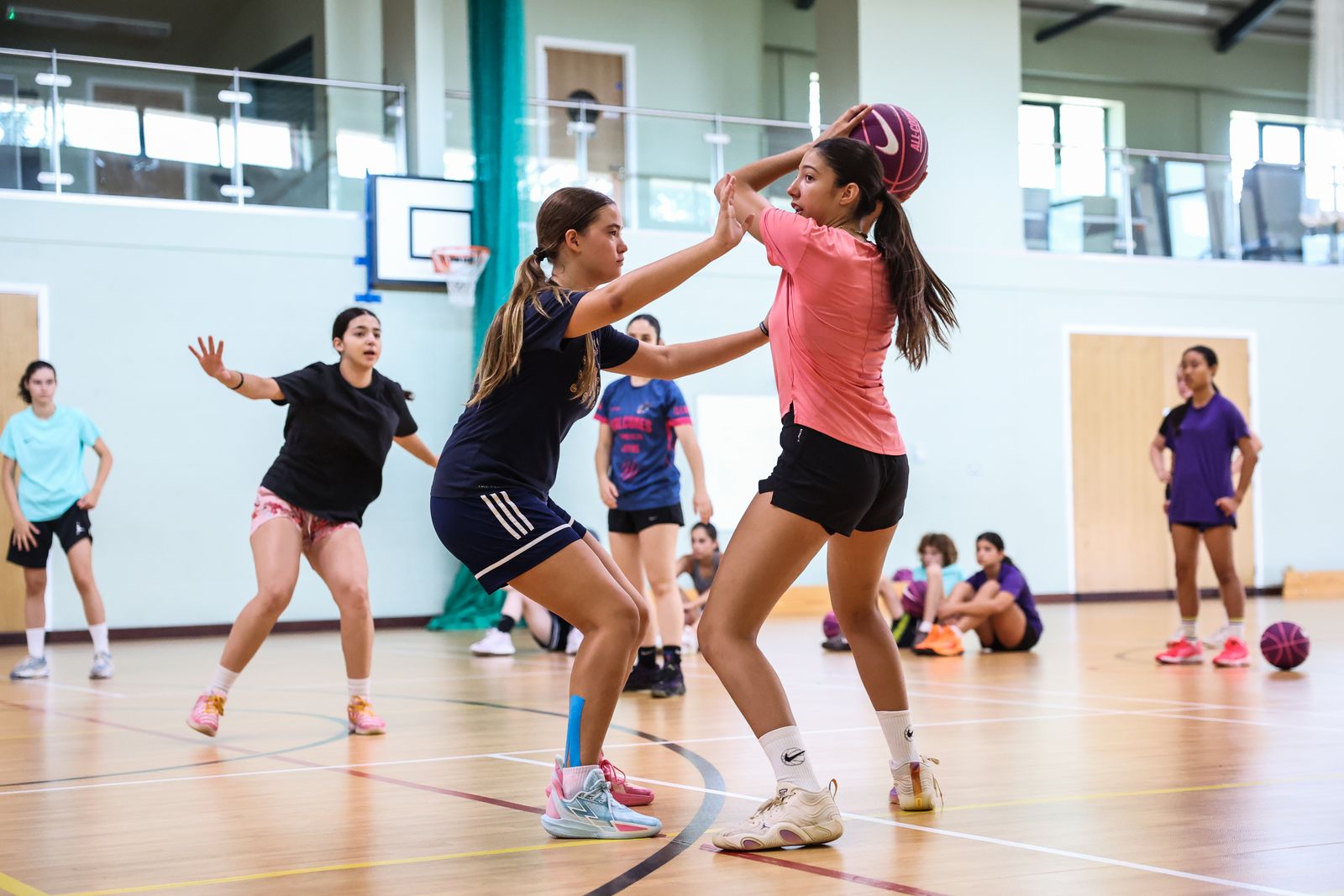 Girls playing a basketball game in the sports hall