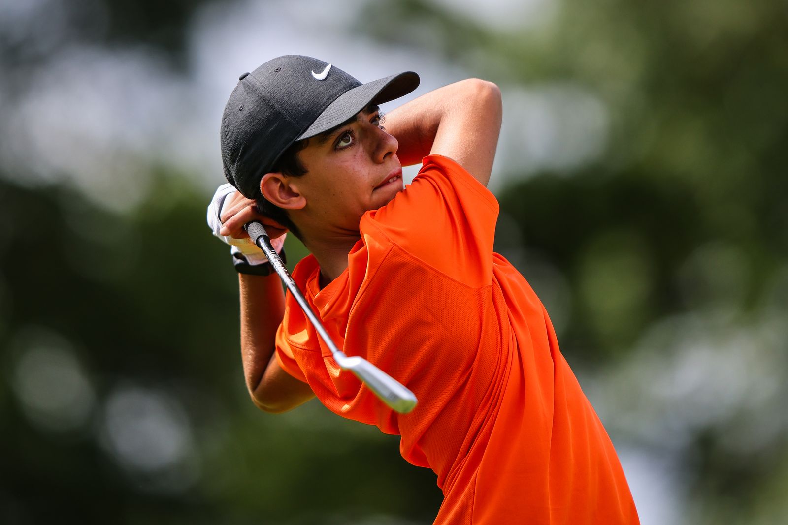 A junior golfer following through on a drive