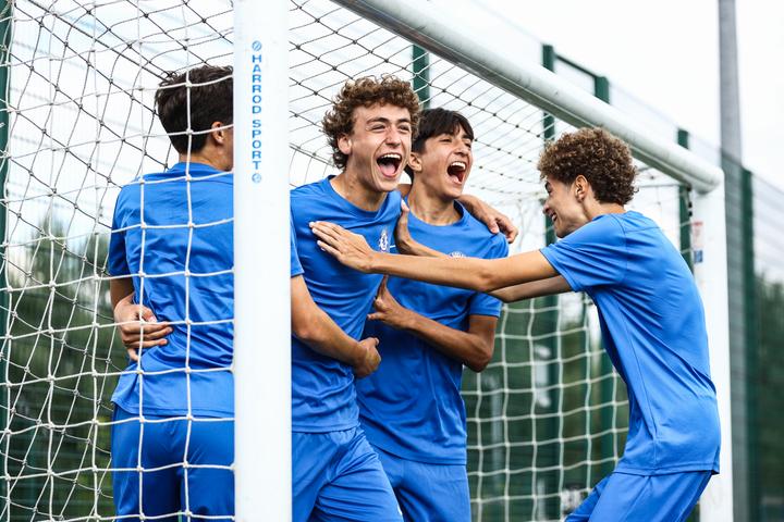 Players celebrating a goal by the net