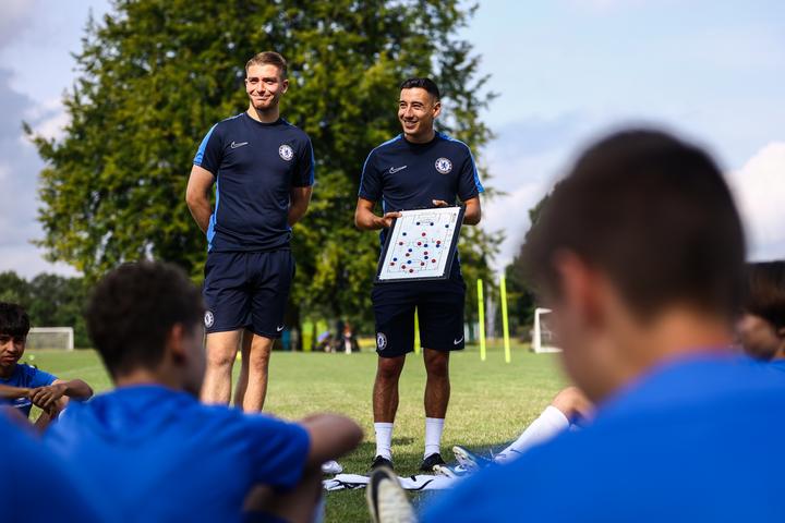 Chelsea FC coaches explaining tactics on a whiteboard