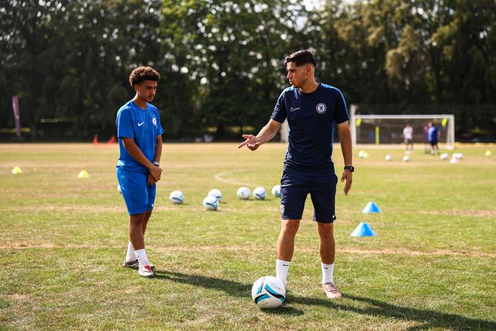 A Chelsea FC coach working one-to-one with a young player