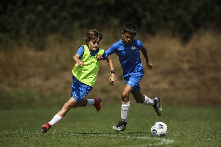 A young player dribbling past a defender