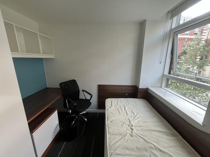 Single room with bed and desk by the window