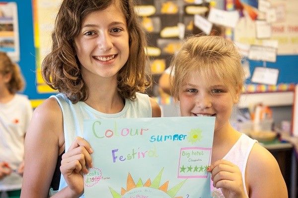 Two girls holding up a poster they made in class