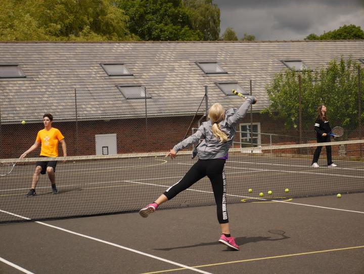 Students playing tennis on the school's outdoor courts