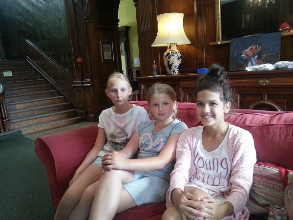 Three girls relaxing on a sofa in a common room