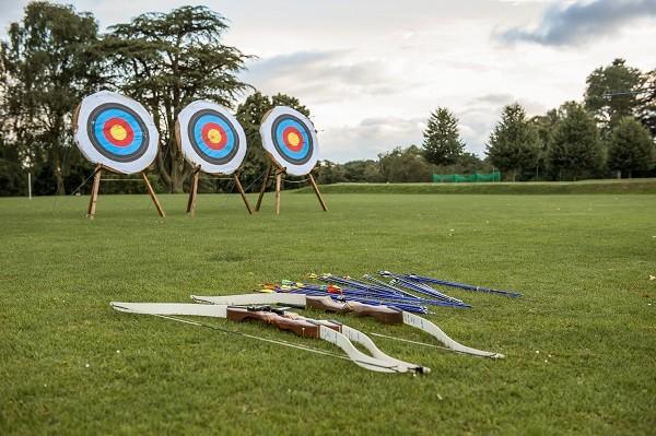 Archery targets and bows laid out on the school field
