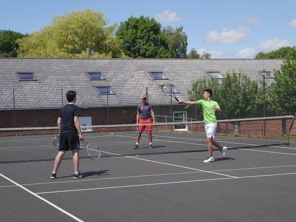 A doubles game on the campus tennis courts