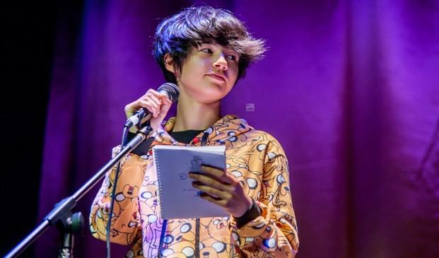 A student speaking into a microphone on stage