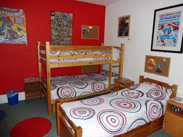 A boys' room with bunk beds and superhero posters
