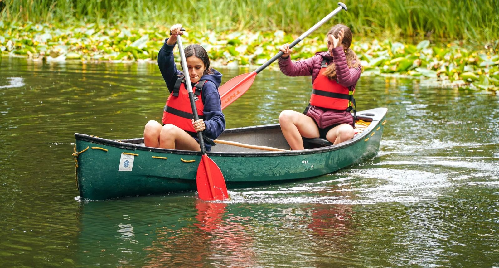 Two campers canoeing on the river