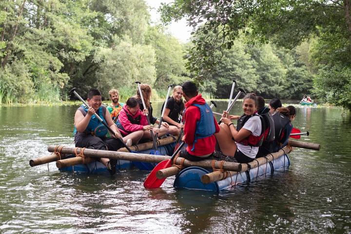 Campers paddling their home-made raft