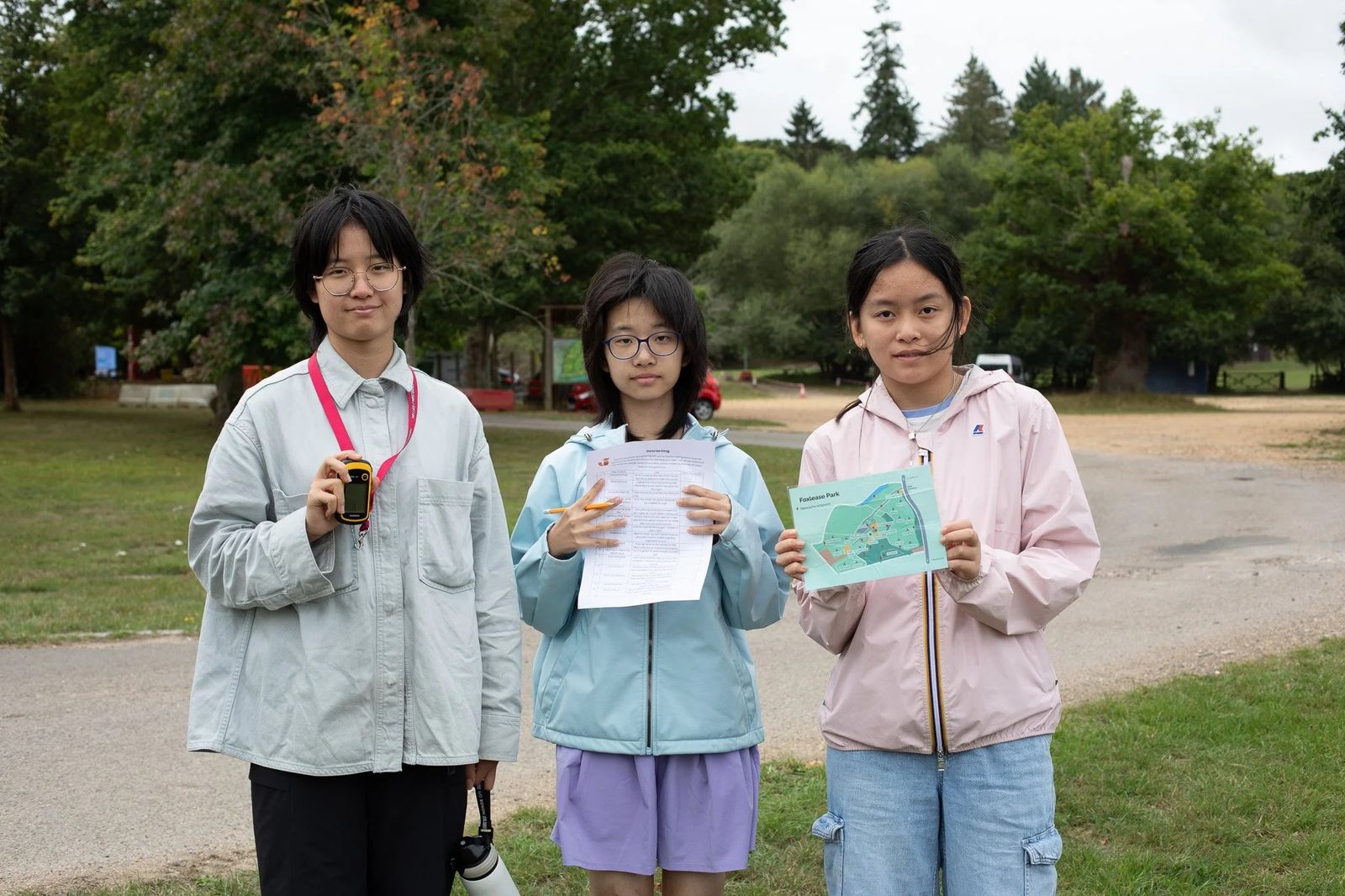 Three students smiling with their course certificates