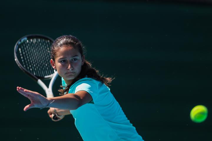 A girl stretching for a low volley