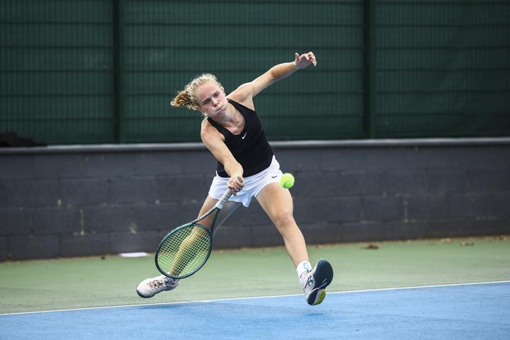 A player lunging wide for a forehand