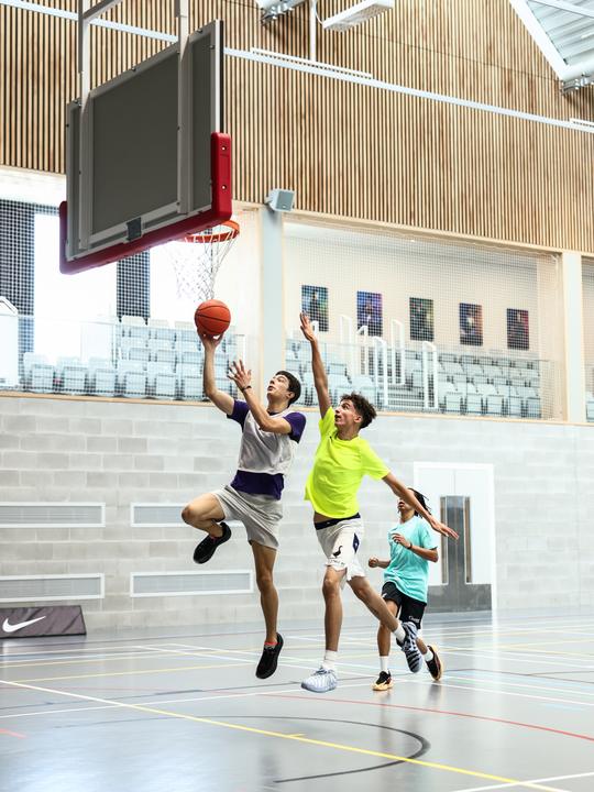 A player driving to the basket in the Winchester sports hall