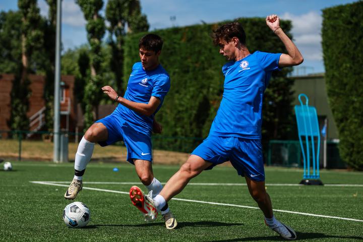 Two older players contesting the ball at speed